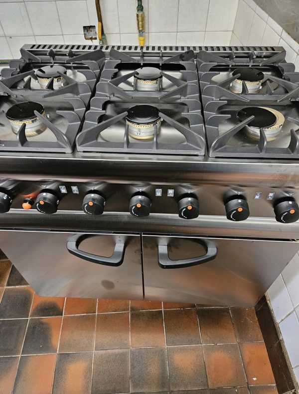 Six-burner commercial gas range with oven, back in service